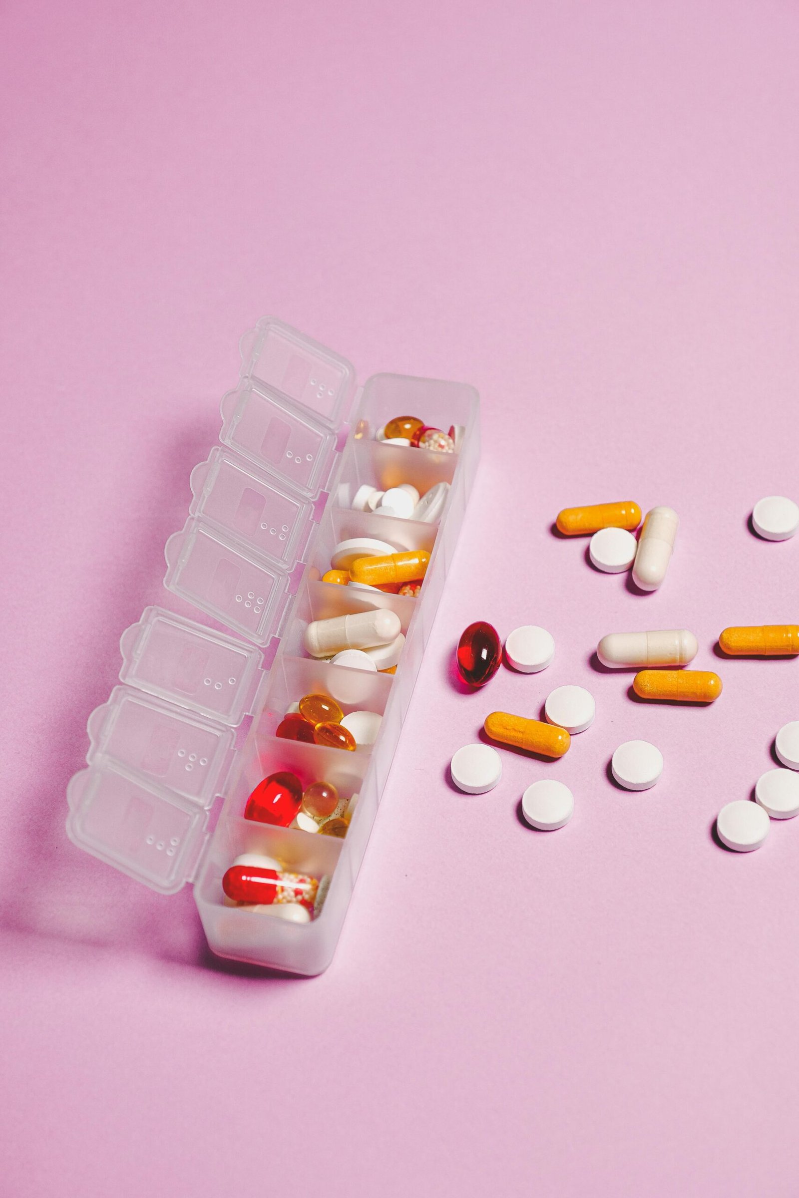 pexels photo 3683042 3683042 Colorful assortment of pills and capsules in organizer on pink backdrop.