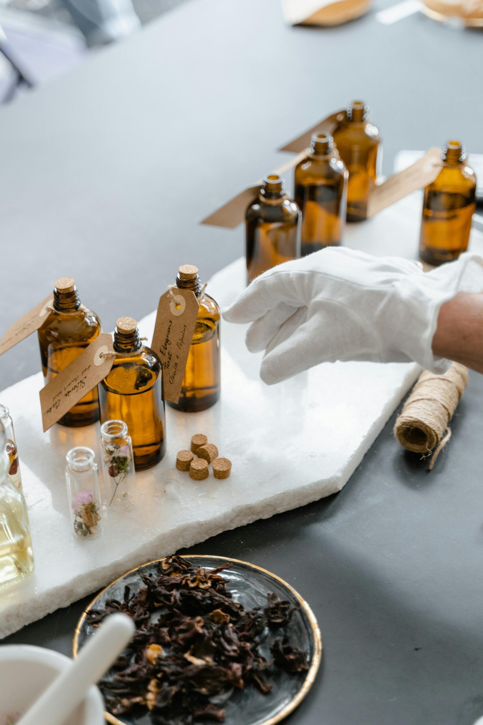 pexels photo 8450399 8450399 Elegant display of amber bottles and dried herbs for aromatherapy on a marble slab.